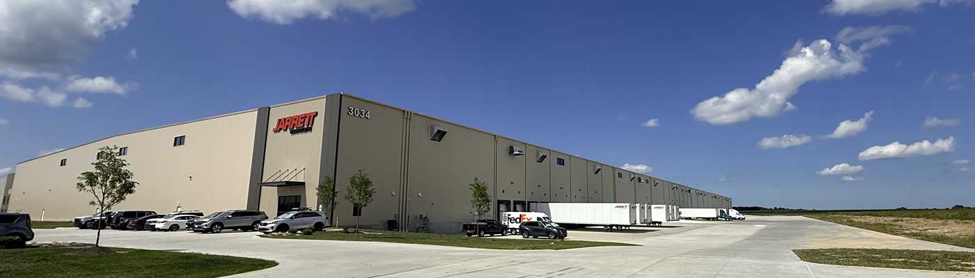Jarrett logistics warehouse facility with parked semi-trailers and cars