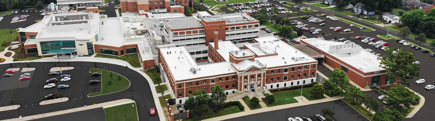 Aerial view of a hospital campus with brick buildings and parking lots.
